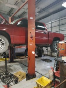 Red pickup truck elevated on garage lift