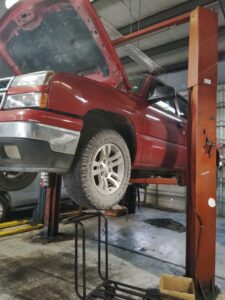 Red pickup truck on lift with open hood