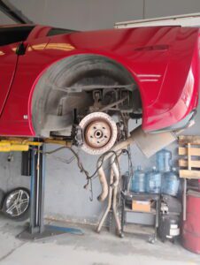 Red car on lift, brake rotor exposed