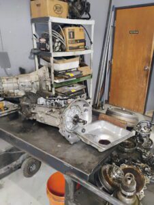 Disassembled car transmission and gears on workbench