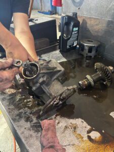 Hands working on differential gears on workbench