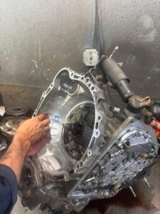 Mechanic hands repairing car transmission assembly